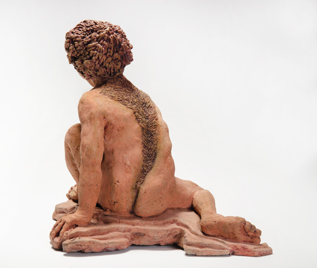 Back View: ENKIDU, the “wild man” companion of the Mesopotamian hero Gilgamesh; a crouching male figure, arms and legs extended, with hair like a lion’s pelt.